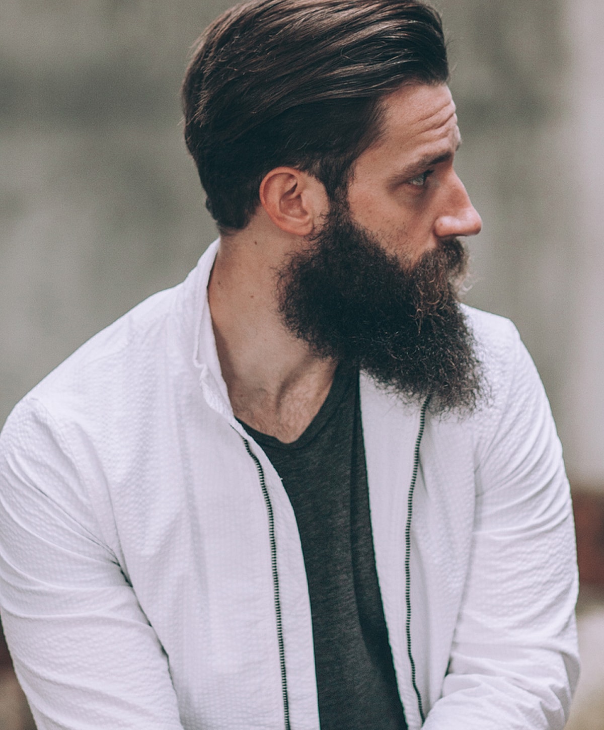 Man with beard in profile, wearing casual jacket.