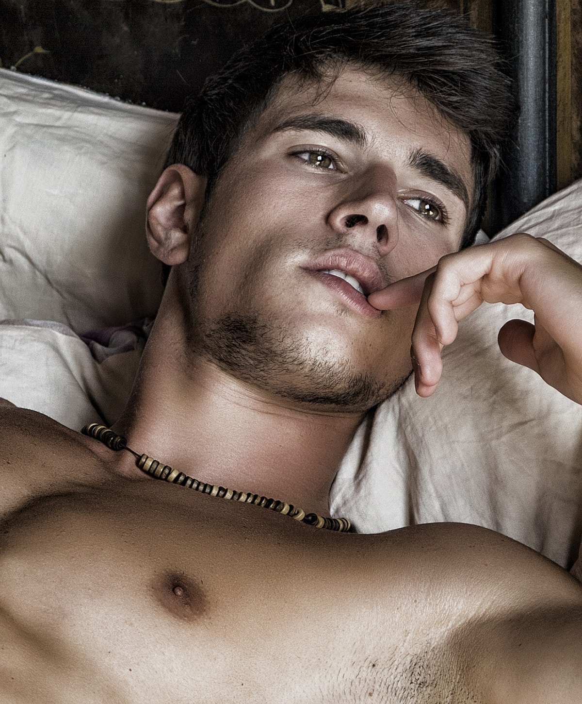 Young man resting with thoughtful expression.