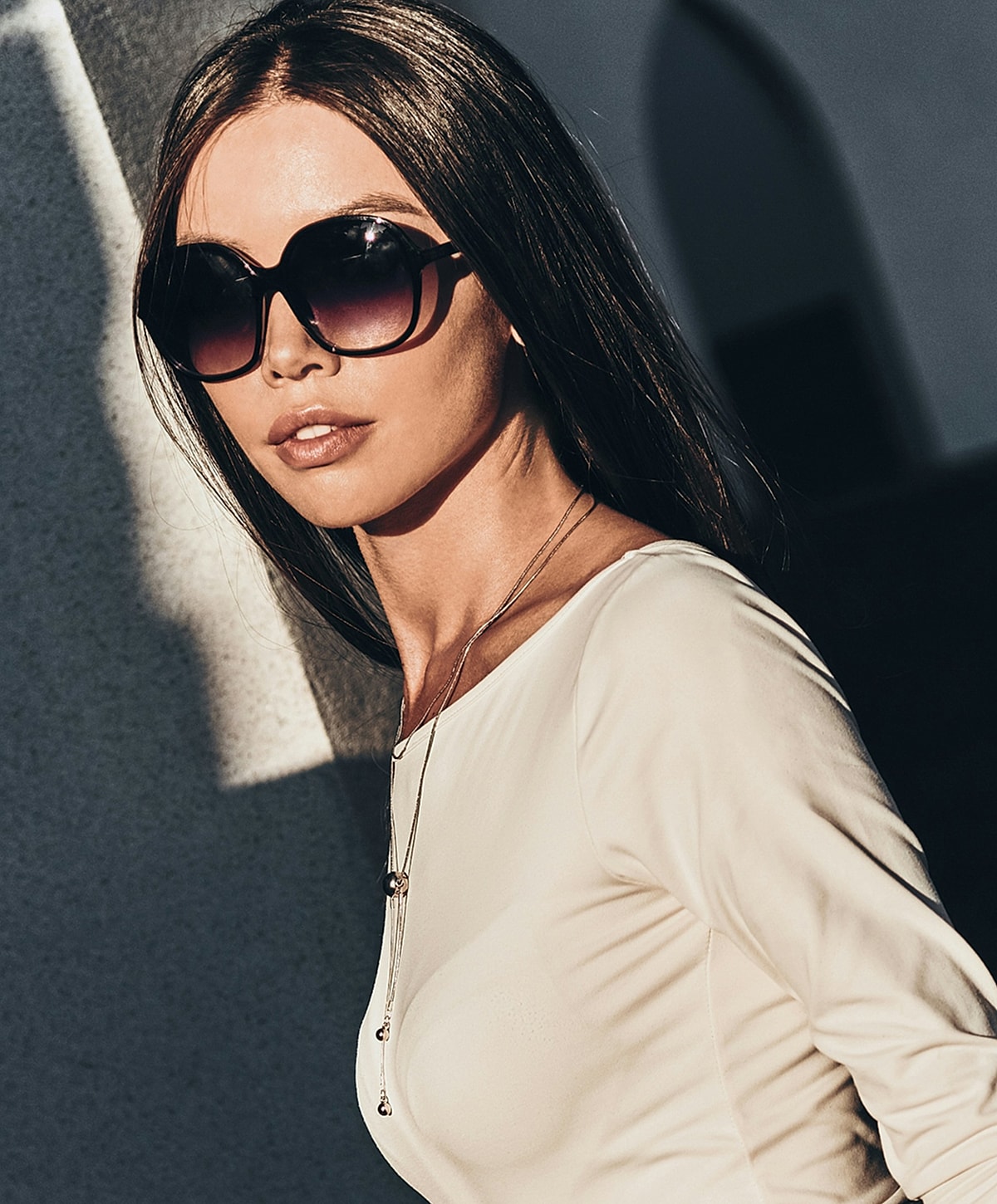 Woman in sunglasses with long hair outdoors.